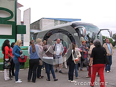 A crowd of people standing near the passengers of the tour bus arrived tourists stop Editorial Stock Photo
