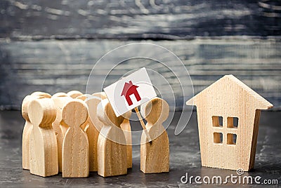 A crowd of people with a poster standing near the house. The concept of finding housing, a new home. High demand for housing Stock Photo