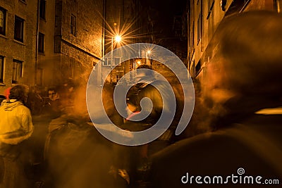 A crowd of people walking and moving through the street at night Editorial Stock Photo