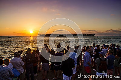 Crowd of people watching a beautiful colorful sunset from Key West with Sunset Key on the horizon. Key West, FL USA - 25/04/2018 Editorial Stock Photo