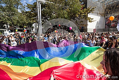 Crowd of protestors holding a giant rainbow gay flag during the 2017 Belgrade Gay Pride, happy and smiling Editorial Stock Photo