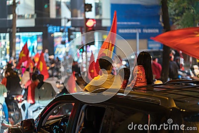 Crowd of Vietnamese football fans down the street to celebrate the win after soccer, with a lot of Vietnamese flags raising high Editorial Stock Photo