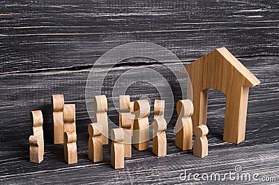 A crowd of wooden people stands at the entrance of the building. Cultural and religious activities, public gatherings. Stock Photo