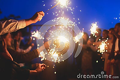 A crowd of young happy people with bengal fire sparklers in their hands during birthday celebration Editorial Stock Photo