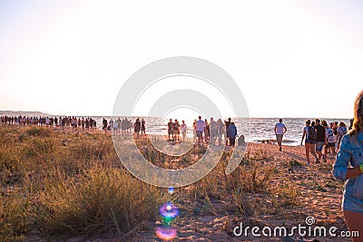 A crowd of young people walk along the seashore at a music festival, summer outdoor activities Editorial Stock Photo