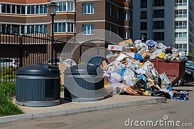 Crowded garbage cans in the courtyard of a residential apartment building. Garbage sorting containers. Trash is Editorial Stock Photo