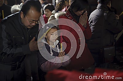 Crowded people kneel down and praying in temple Editorial Stock Photo