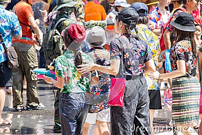 Crowded Thai people in colorful shirts and tourists joy Songkran Festival on the road Editorial Stock Photo