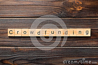 CROWDFUNDING word written on wood block. CROWDFUNDING text on wooden table for your desing, concept Stock Photo
