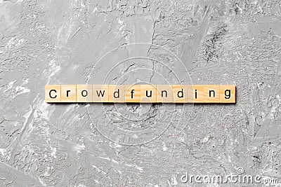 CROWDFUNDING word written on wood block. CROWDFUNDING text on cement table for your desing, concept Stock Photo