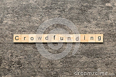 CROWDFUNDING word written on wood block. CROWDFUNDING text on cement table for your desing, concept Stock Photo