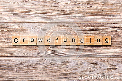 CROWDFUNDING word written on wood block. CROWDFUNDING text on wooden table for your desing, concept Stock Photo