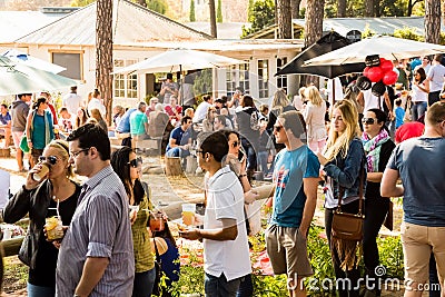 Crowds of diverse people sitting in the beer garden at outdoor farmer`s market Editorial Stock Photo