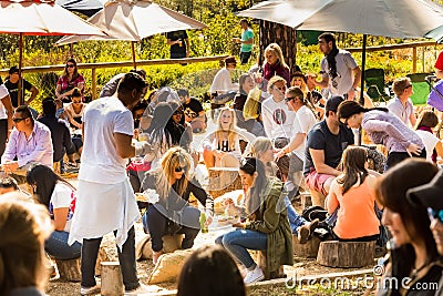 Crowds of diverse people sitting in the beer garden at outdoor farmer`s market Editorial Stock Photo