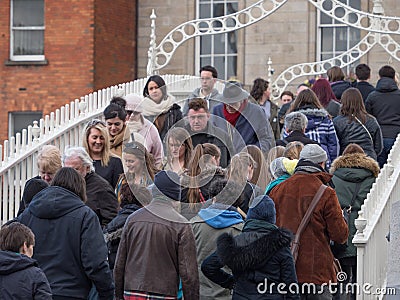 People cross Ha`penny Bridge in Dublin, Ireland Editorial Stock Photo