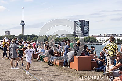 Crowds of people in groups relaxing and socialising in an urban waterfront setting Editorial Stock Photo