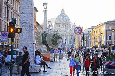 Crowds of people walk near the St Peter`s Basilica at the sunset in Rome, Italy. St Peter`s cathedral in Vatican City is one of Editorial Stock Photo
