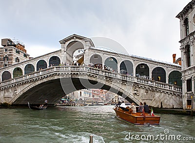 Crowds of tourists on Rialto Bridge and boats in the channel on September 24, 2010 in Venice Italy Editorial Stock Photo