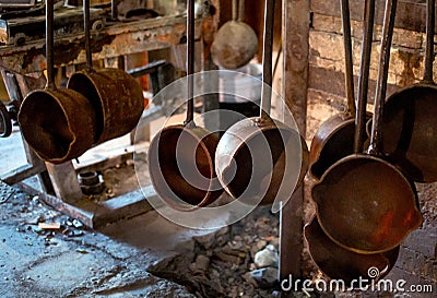 Crucible ladles hang from a rack Stock Photo