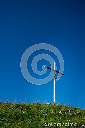 Crucifix on the top of the mountain in the middle of a meadow Stock Photo