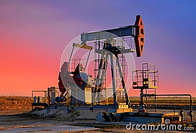 Crude oil pump jack at oilfield on atmospheric sunset backround. Fossil crude output and fuels oil production. Oil drill rig and Editorial Stock Photo