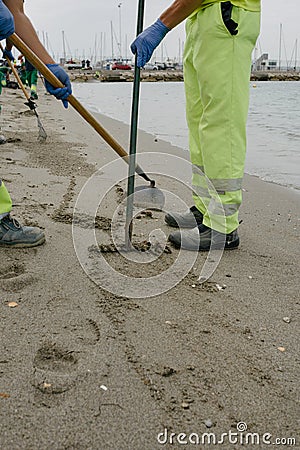 Crude oil spill in Gibraltar and the Andalusian coast. Unrecognizable workers cleaning the sand Editorial Stock Photo