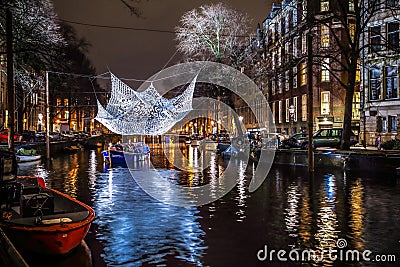 Cruise boats rush in night canals. Light installations on night canals of Amsterdam within Light Festival. Editorial Stock Photo