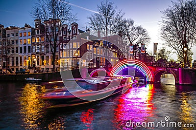 Cruise boats rush in night canals. Light installations on night canals of Amsterdam within Light Festival. Editorial Stock Photo