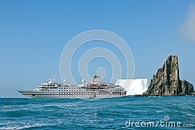 Cruise liner in front of iceberg and ragged rock in Antarctia, Point Wild, Elephant Island Stock Photo