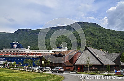 Cruise liner on mooring in sea harbor in Flam. Green mountains of fjord Sognefjord on background Editorial Stock Photo