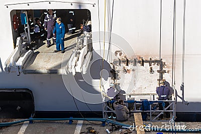 Cruise Ship Maintenance Crew/Staff/Workers carrying out welding work repairs near Tug Area on exterior of ocked ship Editorial Stock Photo