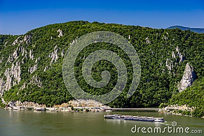 Cruise ship passing by rock sculpture of Decebalus in Danube gorge Editorial Stock Photo