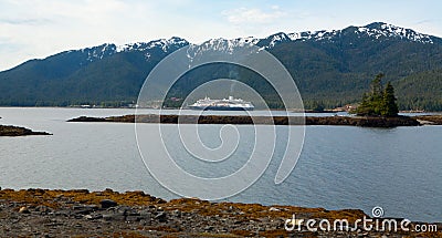 Cruise ship sailing in front of Alaskan mountains during summer Stock Photo