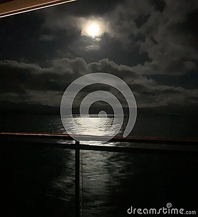 Cruising by moonlight reflected in the sea Stock Photo