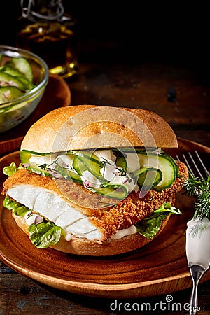 Crumbed fish burger with cucumber Stock Photo
