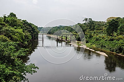 Crumbling iron and concrete bridge crossing Munaya river in rain forest of Cameroon, Africa Stock Photo