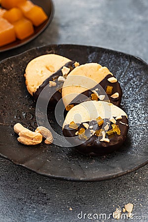 Crumbly vanilla-chocolate homemade cashew cookies and mango marmalade on a gray background. natural sweets. cozy tea Stock Photo