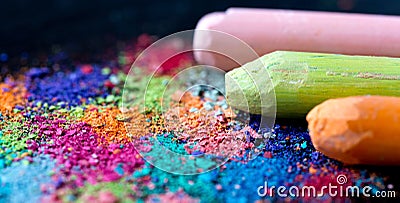 Crumbs of multi-colored chalk on a black background. Joy, Carnival, Panorama. A game for children. Art Stock Photo