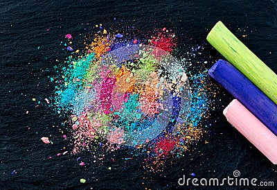 Crumbs of multi-colored chalk on a black background. Joy, Carnival, Panorama. A game for children. Art Stock Photo