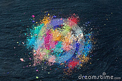 Crumbs of multi-colored chalk on a black background. Joy, Carnival. Panorama. A game for children. Art Stock Photo