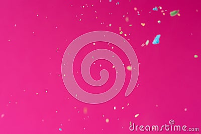 Crumbs of a multicolored chalk fly on a pink background. Joy, Carnival. Game for children Stock Photo