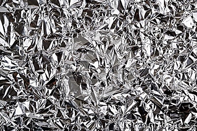 Crumpled aluminum foil texture. Sheet of creased silver foil with shiny folds for background. Metal wrinkled surface as graphic Stock Photo