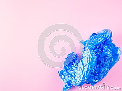 Crumpled blue plastic trash bag on pink background Stock Photo