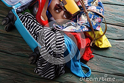 Crumpled clothes in blue suitcase. Stock Photo