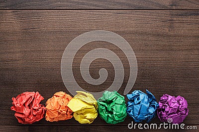 Crumpled colorful paper on wooden background Stock Photo