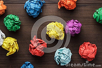 Crumpled colorful paper on wooden background Stock Photo