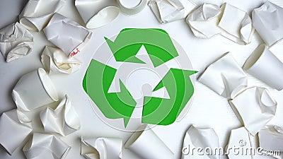 Crumpled disposable paper cups lying around recycling sign, save nature concept Stock Photo