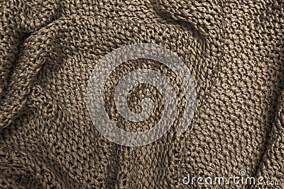 Crumpled folded brown knitted fabric background, woolen knitwear close up Stock Photo