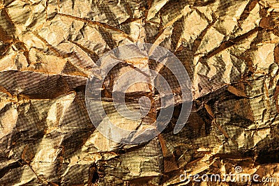 Crumpled gold colored aluminum tin foil texture as background Stock Photo