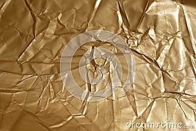 Crumpled gold-colored paper. Stock Photo